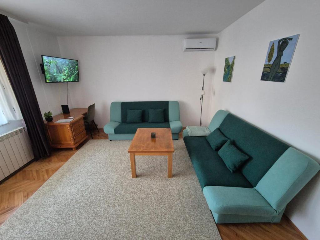 ein Wohnzimmer mit einer Couch und einem Couchtisch in der Unterkunft Apartman Pasarela - mirna lokacija u centru in Bihać