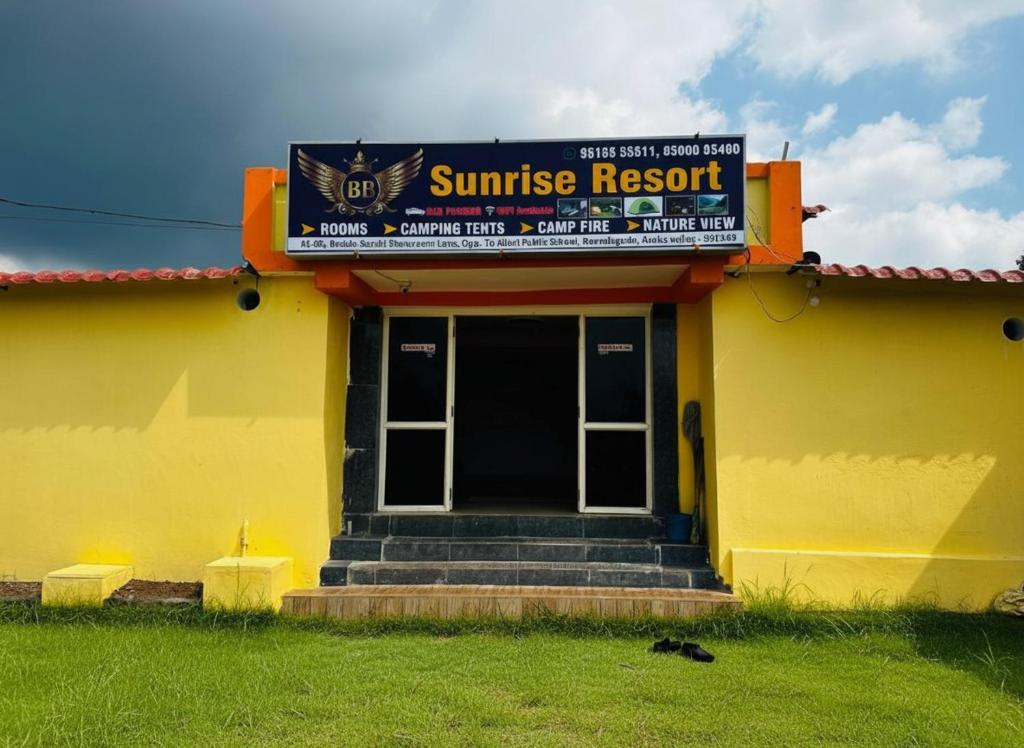 a yellow building with a sunset resort sign on it at Sunrise Resort in Araku