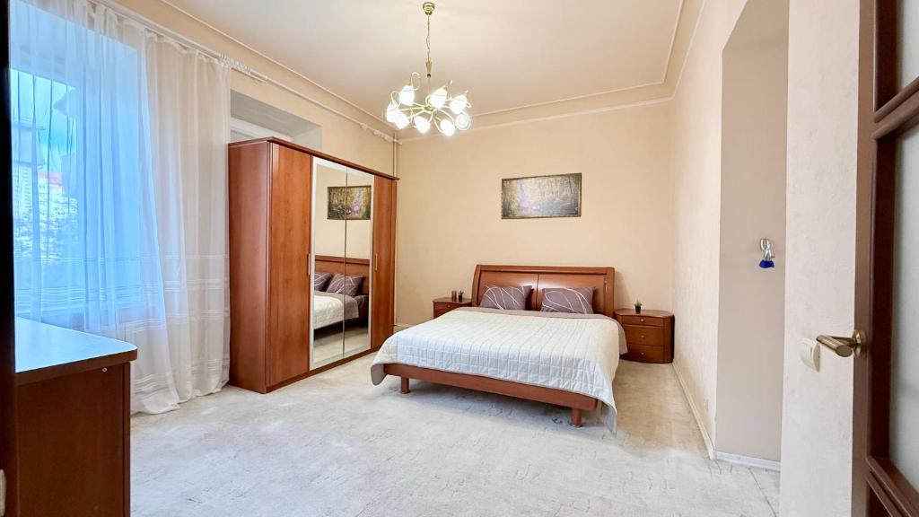 een slaapkamer met een bed en een grote spiegel bij Апартаменты на Лермонтовской in Charkov