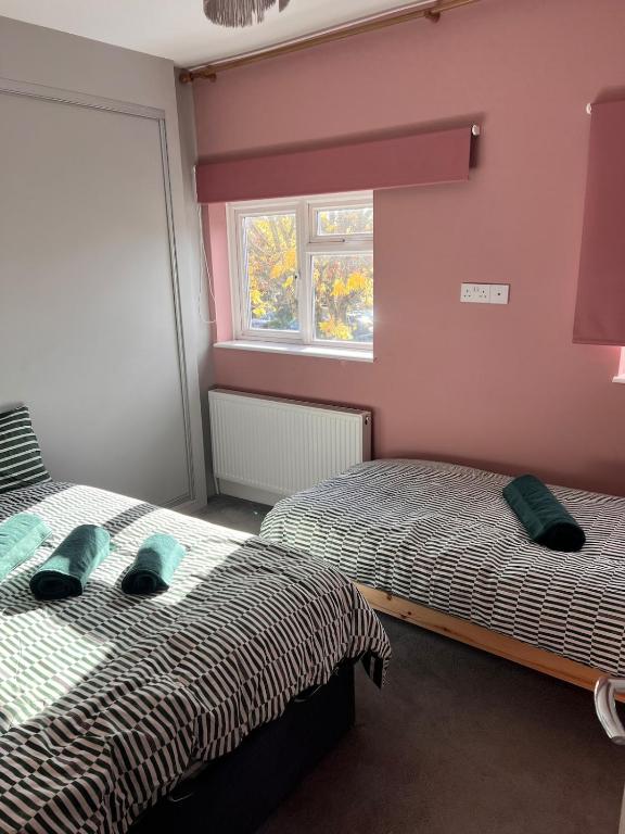 ein Schlafzimmer mit zwei Betten und einem Fenster in der Unterkunft Leamington Spa Town House, cosy central house in Leamington Spa