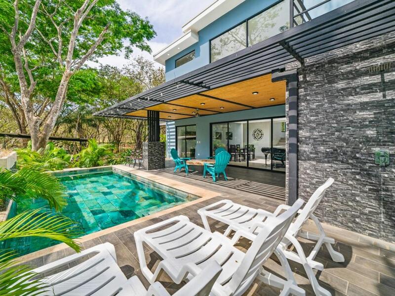 a group of white chairs and a swimming pool at The Wave House in Santa Cruz