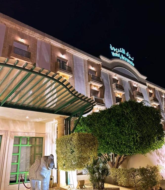 a hotel building with a statue in front of it at Acropole Tunis in Tunis