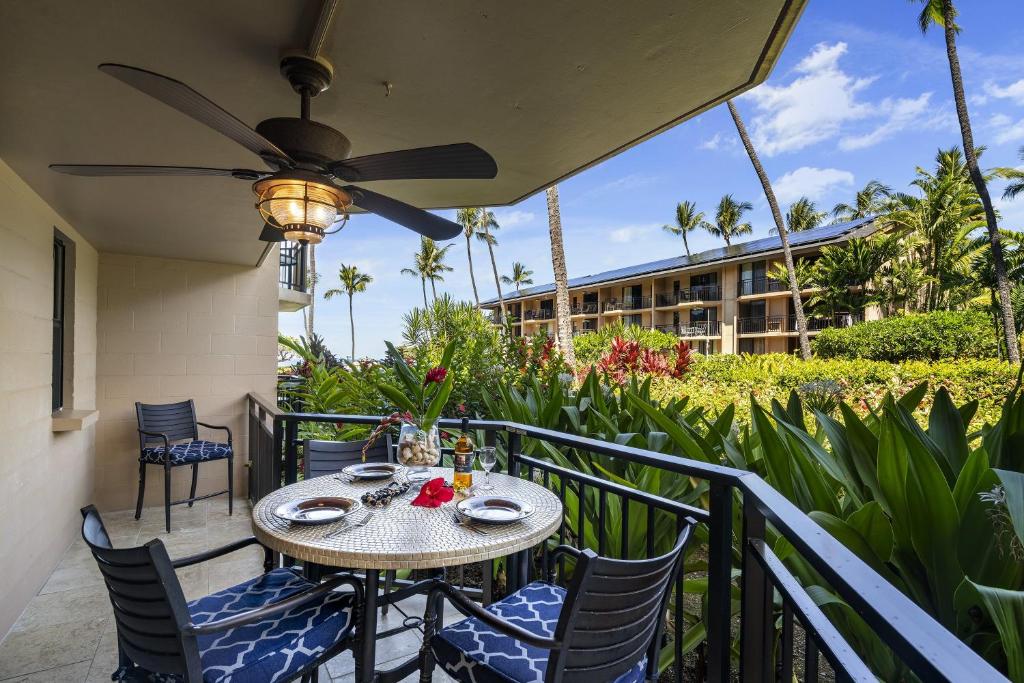 un tavolo e sedie su un balcone con ventilatore a soffitto di Kona Makai 2103 a Kailua-Kona