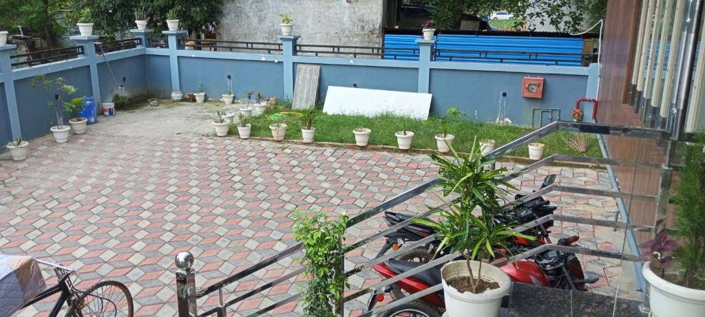a group of motorcycles parked in a courtyard with plants at Hotel Seth Villas in Varanasi