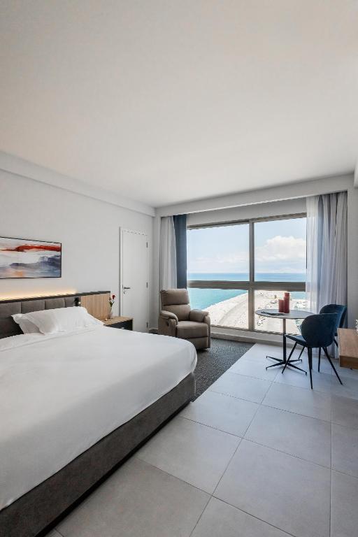 a bedroom with a large bed and a desk and chair at The View - Saint George Hotel in Beirut