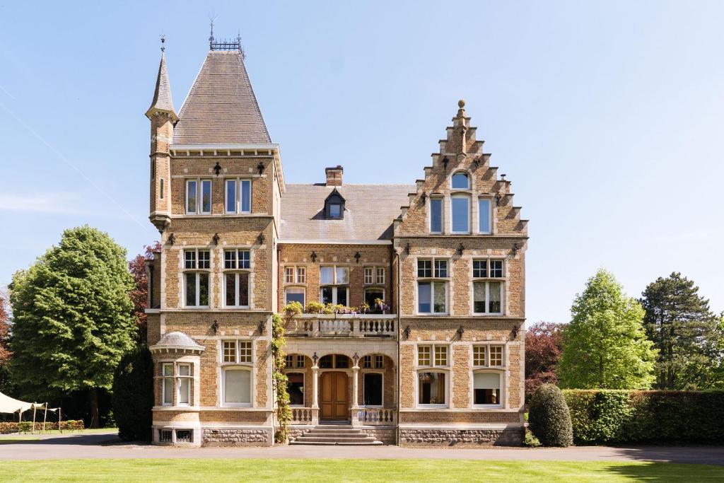 an old house with a balcony in front of it at Kasteel Ter Wallen - Boutique Hotel in Izegem