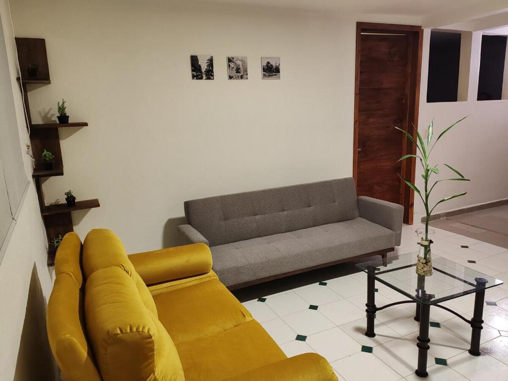a living room with a yellow couch and a gray couch at Casa Xico 424- Centro, Xicotepec, Puenlo Magico in Xicotepec de Juárez