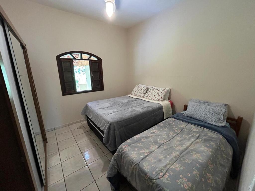 ein Schlafzimmer mit zwei Betten und einem Fenster in der Unterkunft Casa na serra da Mantiqueira in São José dos Campos