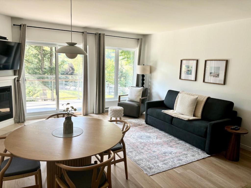 ein Wohnzimmer mit Sofa und Tisch in der Unterkunft Ski in out condo sur la montagne in Bromont