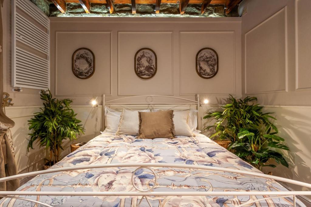 ein Schlafzimmer mit einem Bett mit zwei Topfpflanzen in der Unterkunft Elegante Appartamento a 2 passi dal centro storico in Florenz