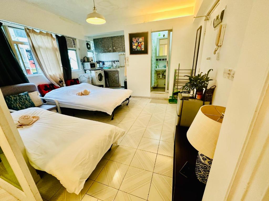 Una sala de estar con dos camas y una cocina. en Spacious House Near Soho & PmQ, en Hong Kong