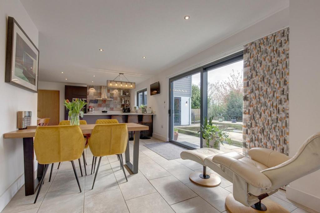 a kitchen and dining room with a table and yellow chairs at Kim's Place in Hingham