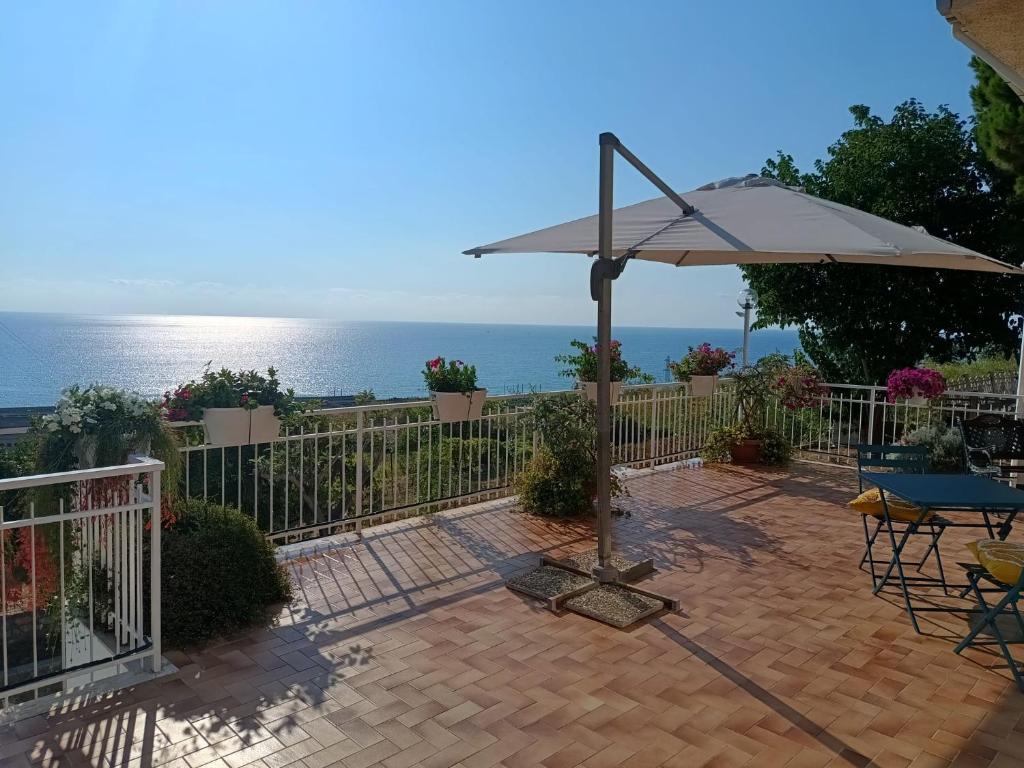 a patio with an umbrella and a table and chairs at Margareth suite and terrace in San Lucido