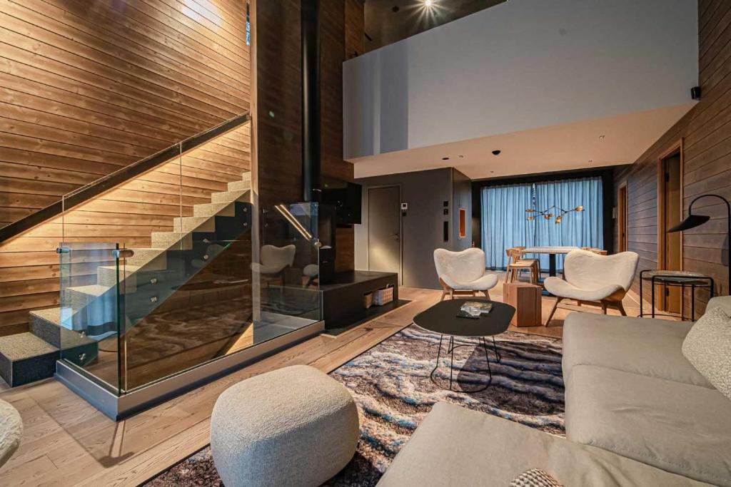 a living room with a couch and chairs and a staircase at Villa Lumi 2 Levi in Kittilä