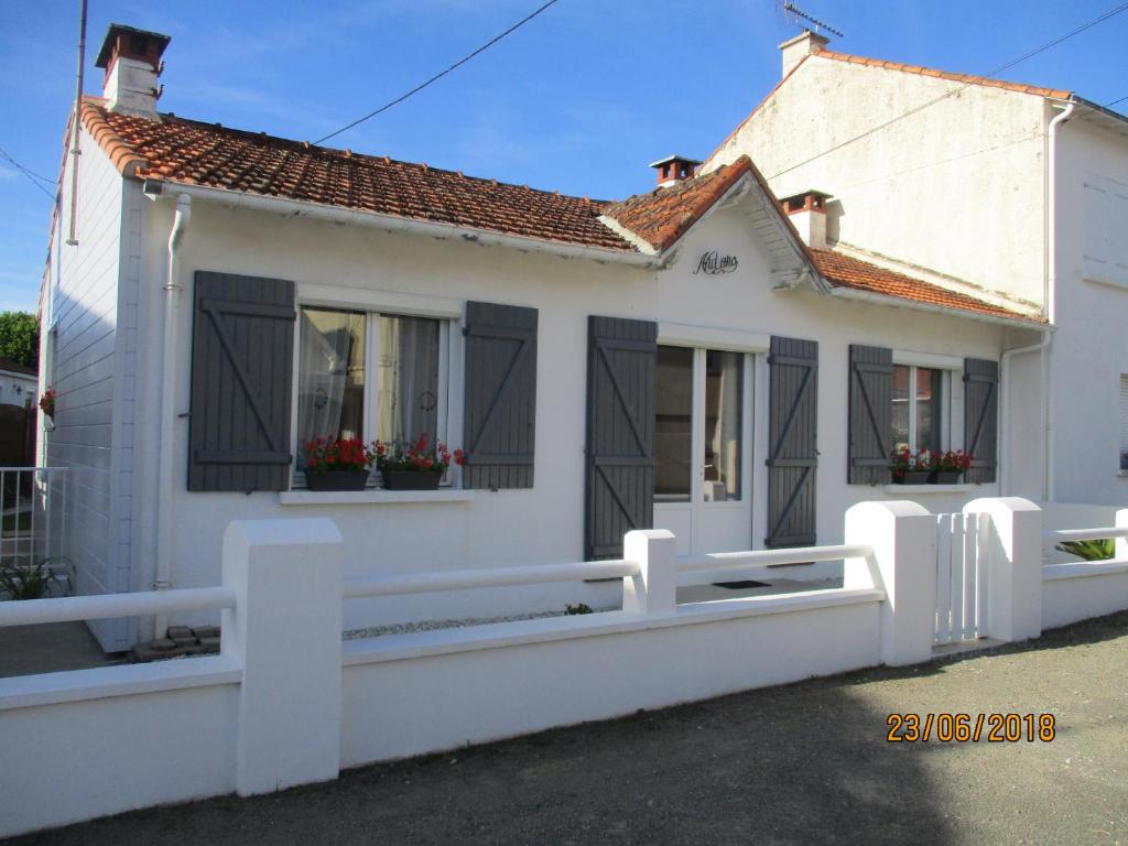 une maison blanche avec des fenêtres noires et une clôture blanche dans l'établissement aldaro, à La Celle-sous-Gouzon