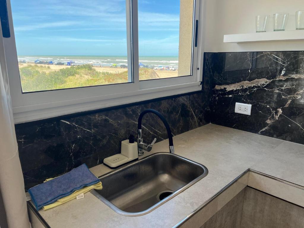 a kitchen sink with a view of the ocean at Loft Paraíso Costero in Mar de Cobo