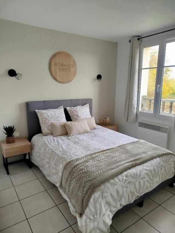 a bedroom with a large bed with white sheets and pillows at Chez Louis in Levernois