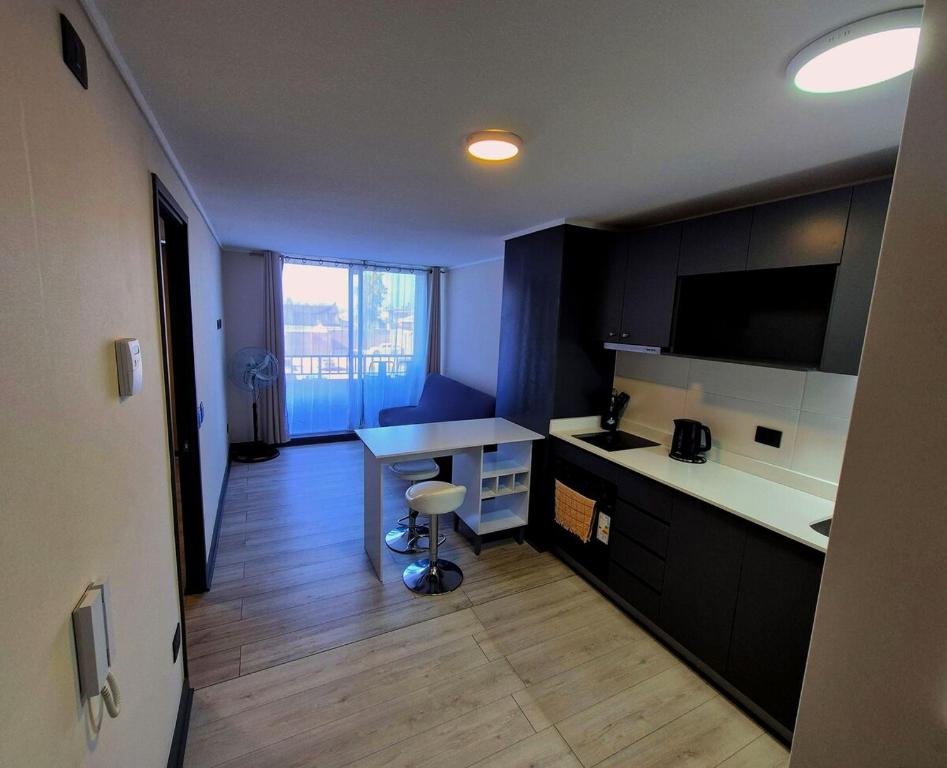 a kitchen with a counter and a table in it at Tu lugar ideal en el sector ideal de Santiago in Santiago