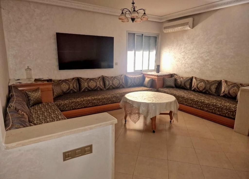 a living room with a large couch and a table at Nobilium in Meknès