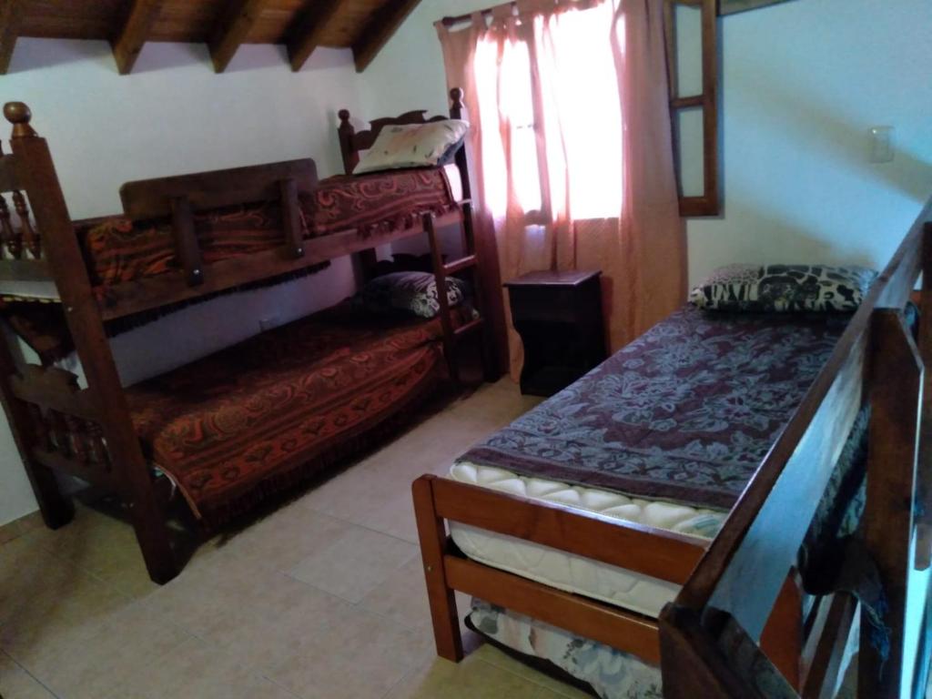 1 Schlafzimmer mit 2 Holzbetten und einem Fenster in der Unterkunft Triplex Oro San Bernardo 2 in San Bernardo
