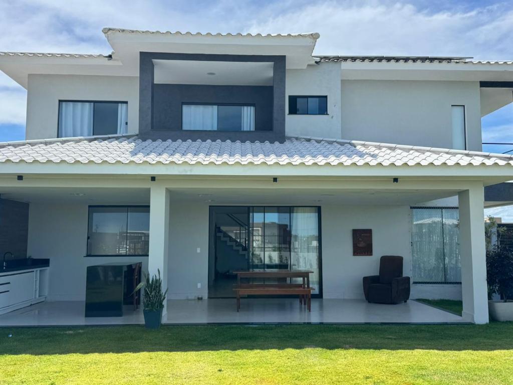 een wit huis met een bankje ervoor bij Morada de Gaudi in Porto Seguro