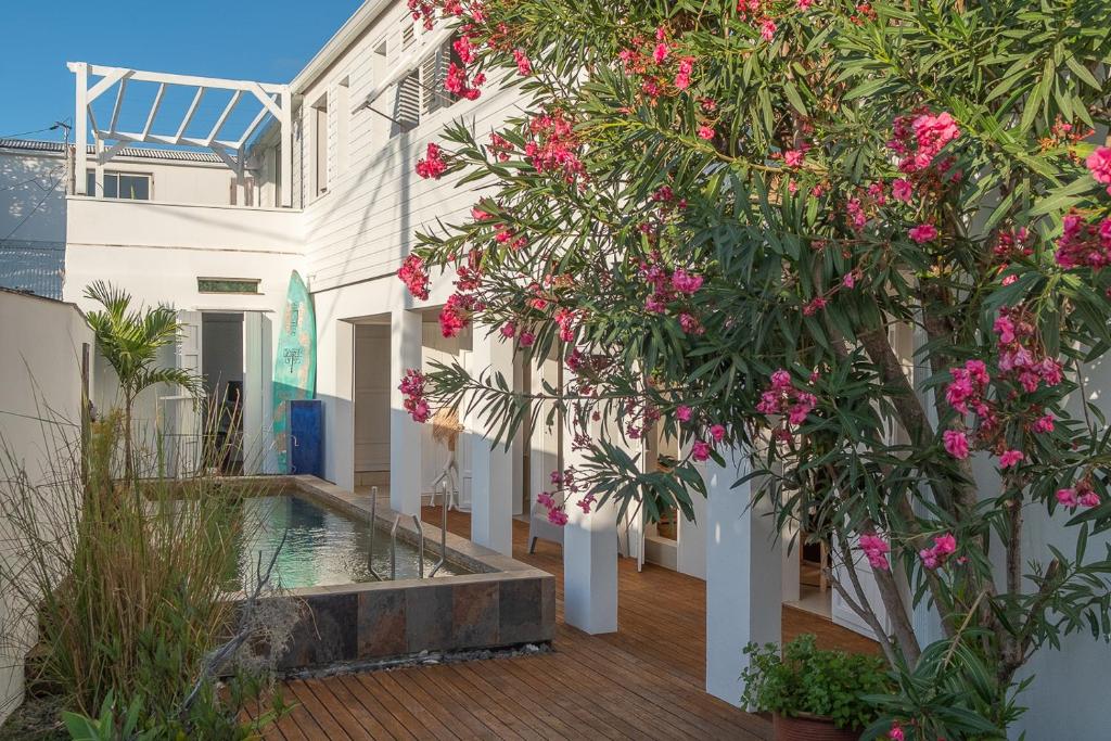 a courtyard of a building with pink flowers at La Kazaka Terre Sainte in Saint-Pierre