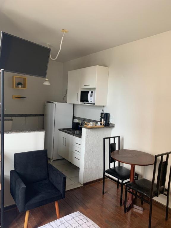 a kitchen with a table and two chairs and a table and a kitchen with at Kit Dom José in Araxá