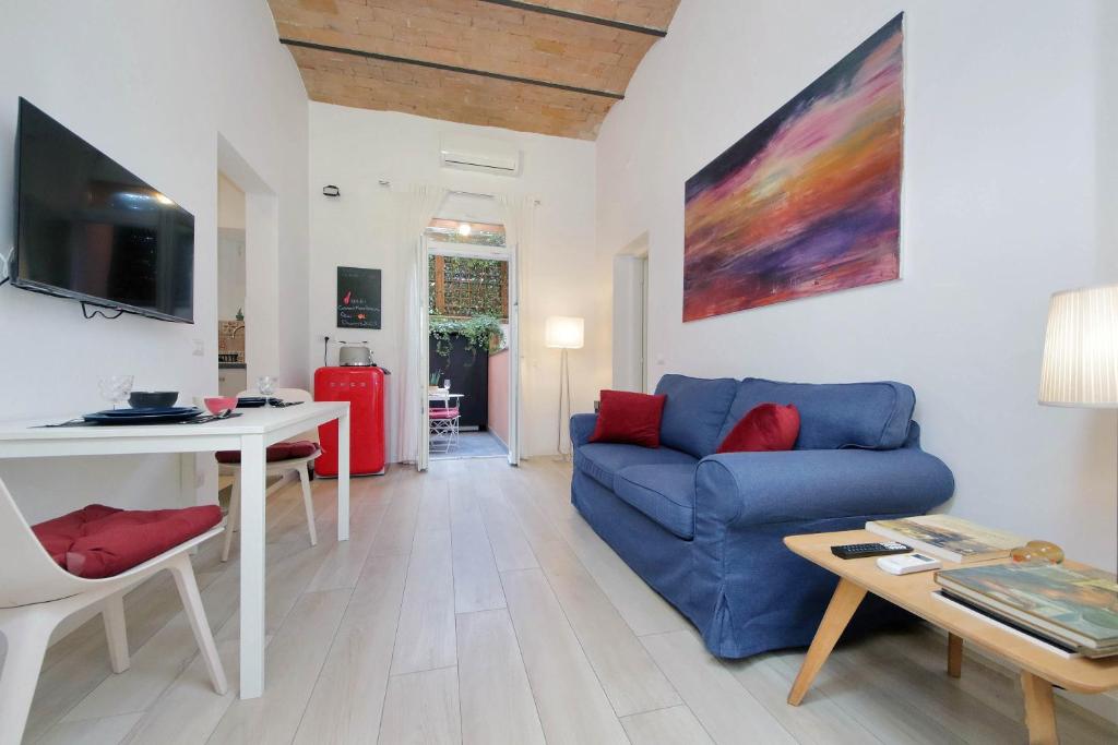 Una sala de estar con un sofá azul y una mesa. en Colosseo Mon Amour, en Roma