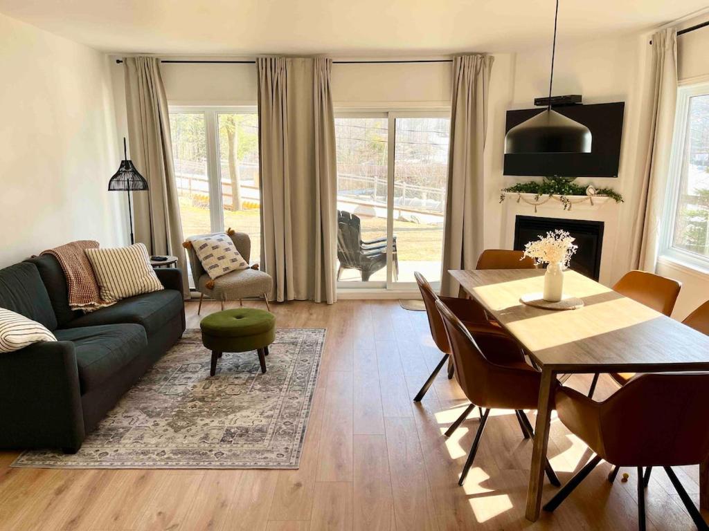 a living room with a couch and a table at Ski in out au pied des pentes in Bromont