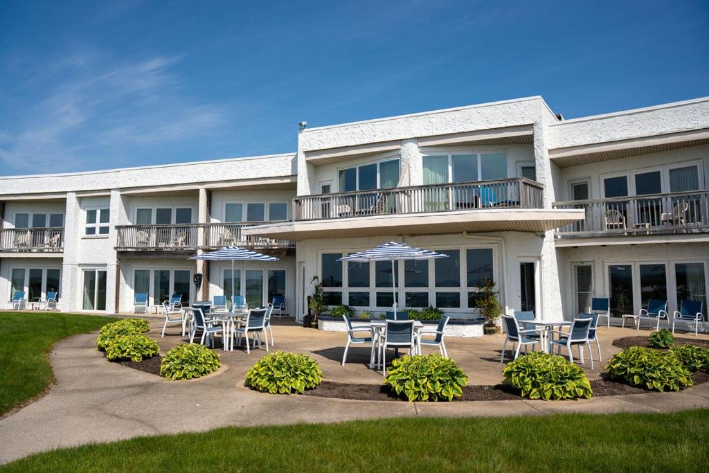 a building with tables and chairs in front of it at Surf & Sand Beach Motel in South Yarmouth