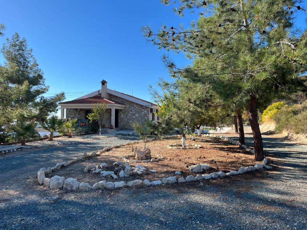 a house with a yard with trees and rocks at House on a Hill with Stunning Views near Troodos in Silikou