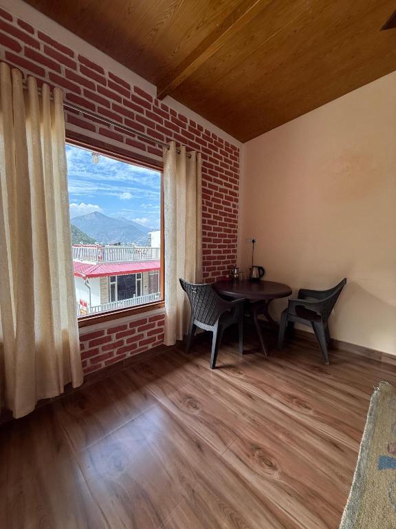 a dining room with a table and a large window at Chandra homestay kainchi dham in Rāmgarh