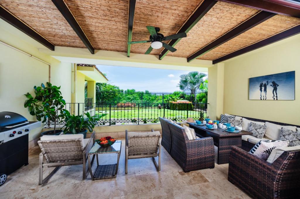 eine Terrasse mit Sofa, Stühlen und einem Tisch in der Unterkunft Stunning Remodeled Beachfront Condo! in Tamarindo