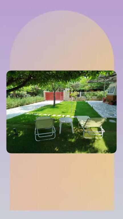 a backyard with a picnic table and two chairs at DamAnda mare in Nea Potidaea