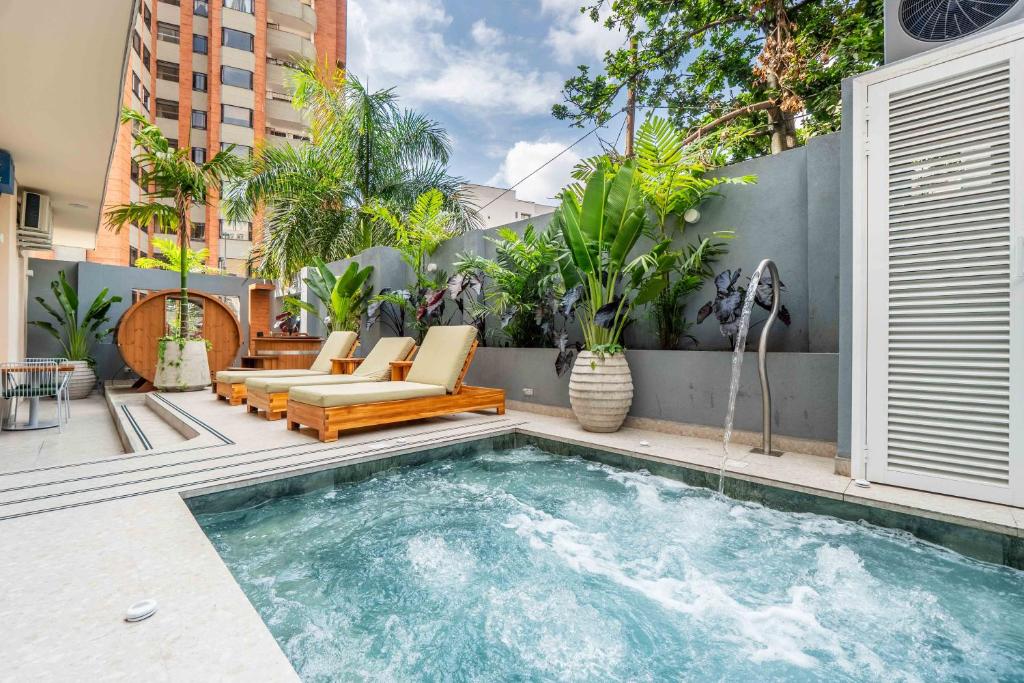 a swimming pool in a backyard with a couch and chairs at Veca Flats Centenario in Cali