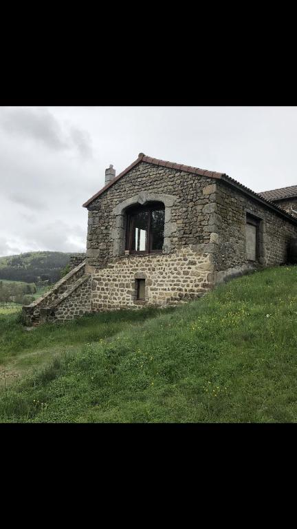 an old stone building on a grassy hill at Maison sur le chemin de compostelle in Thoras