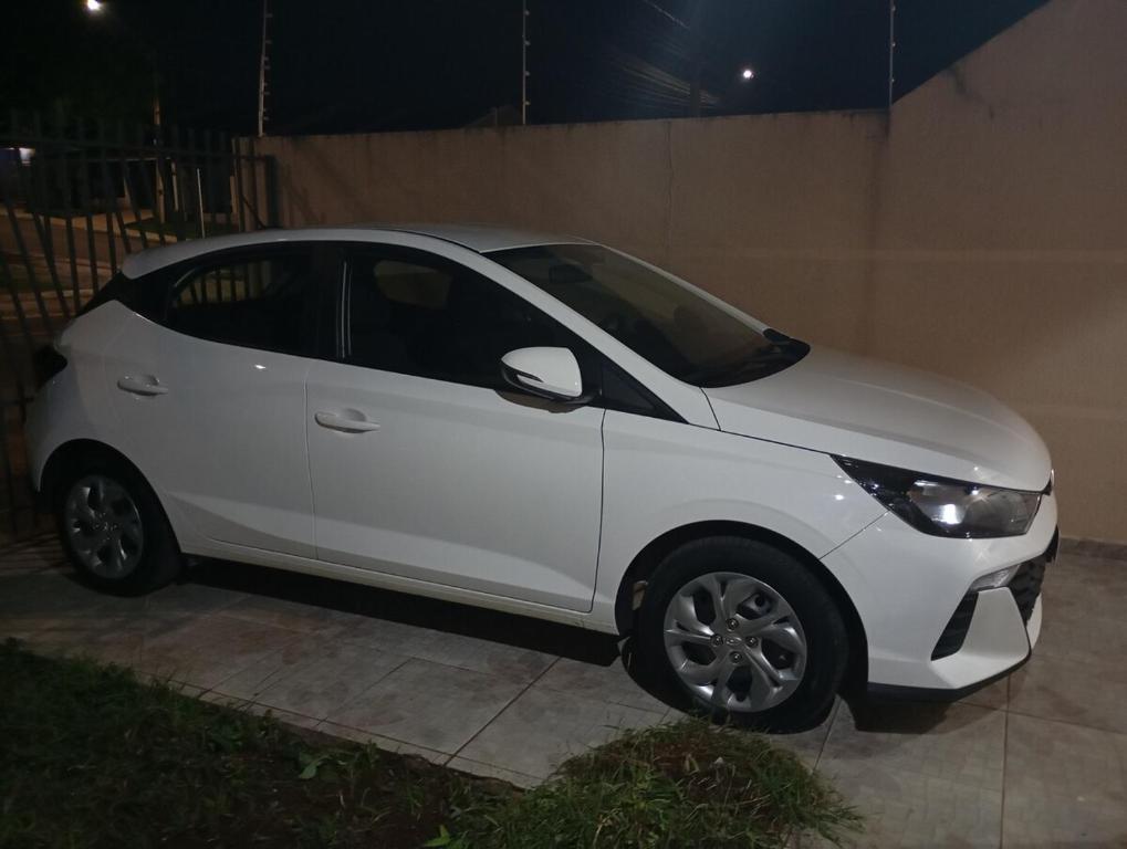 a white car parked on a sidewalk at night at Casa com garagem 4 pessoas in Ponta Grossa