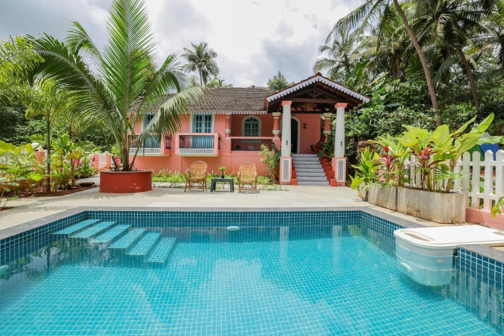 a house with a swimming pool in front of a house at The Village Casa in Aldona