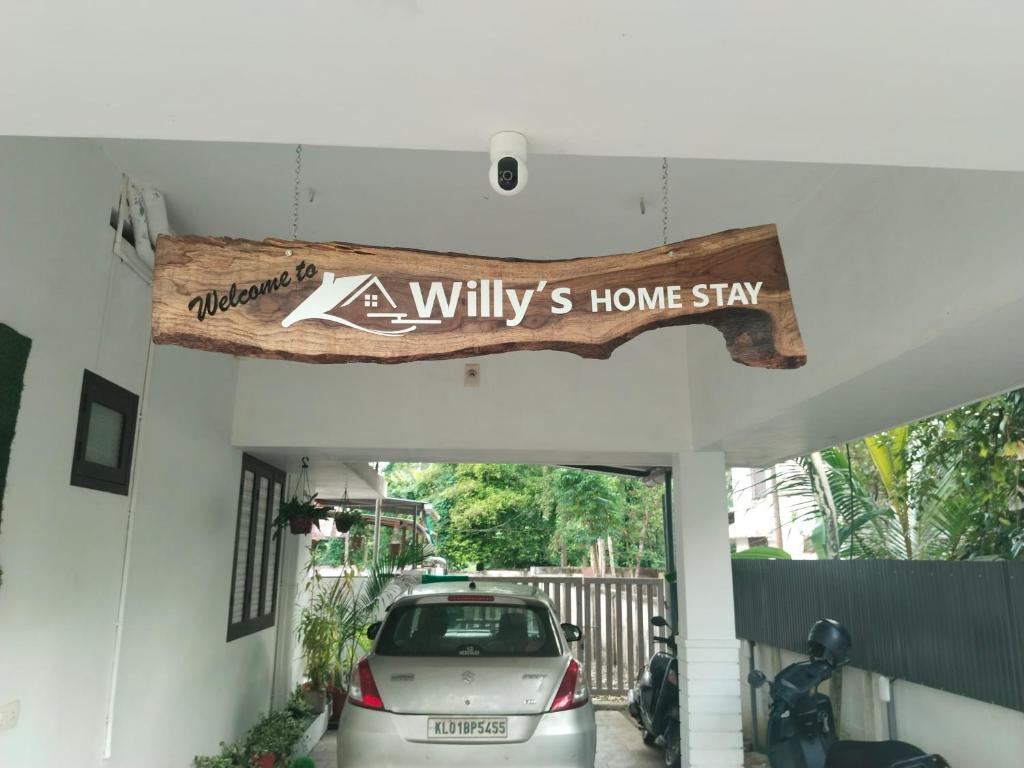 a car parked in a garage with a sign at Willy's Home Stay in Parūr