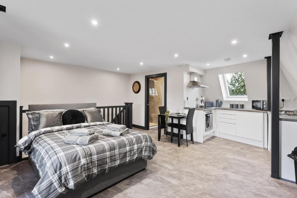 Un dormitorio con una cama grande y una cocina. en Edinburgh City Penthouse Studio, en Edimburgo