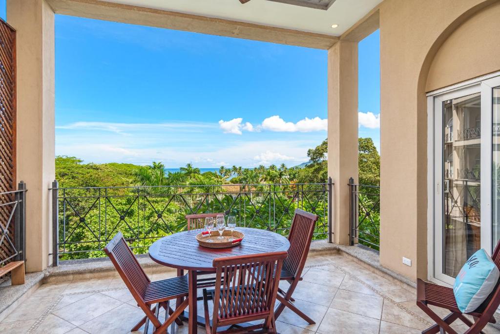um pátio com uma mesa e cadeiras em uma varanda em Beautiful Ocean View Condo Steps To The Beach em Tamarindo