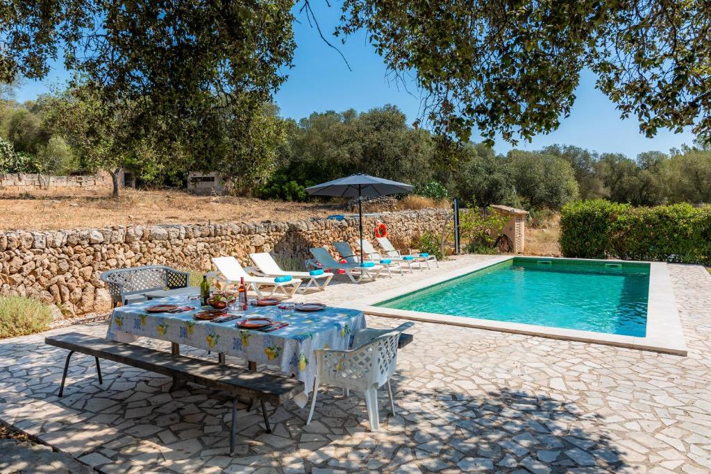 a patio with a table and chairs next to a swimming pool at Can Gallot De Punxuat - Pool in Algaida