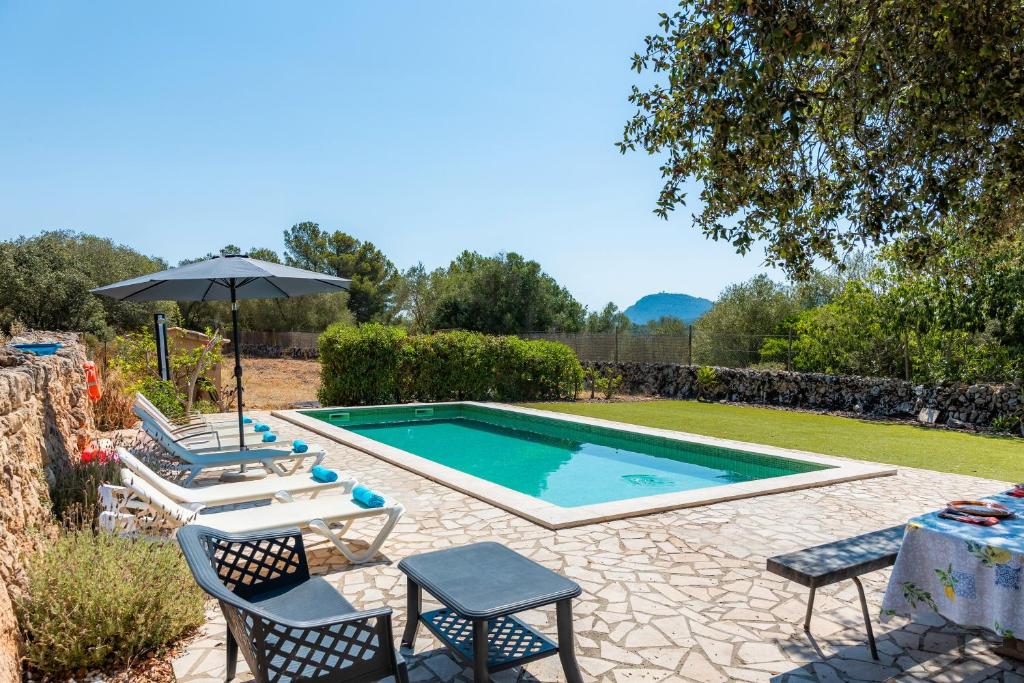 a swimming pool with two chairs and an umbrella at Can Gallot De Punxuat - Pool in Algaida