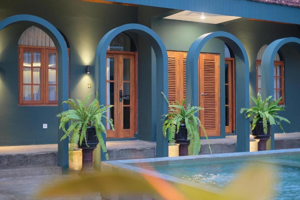 a house with two palm trees in front of a swimming pool at Agung Guest House by RF in Timuran