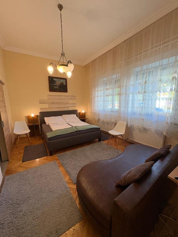 een slaapkamer met een bed en een bank bij Amicii apartman in Makó