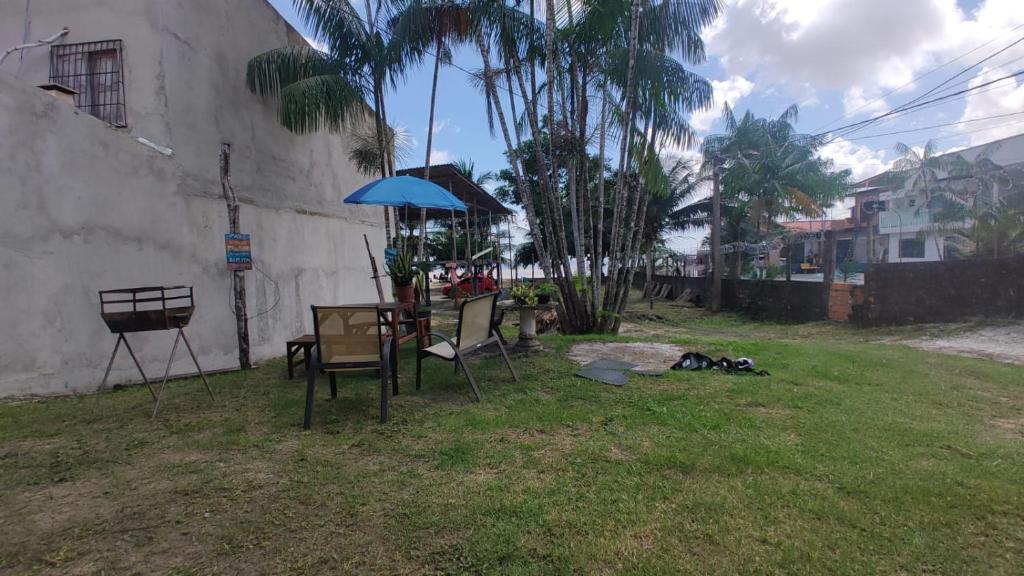 a table and chairs and an umbrella in a yard at Chalé Praia Doce in Belém