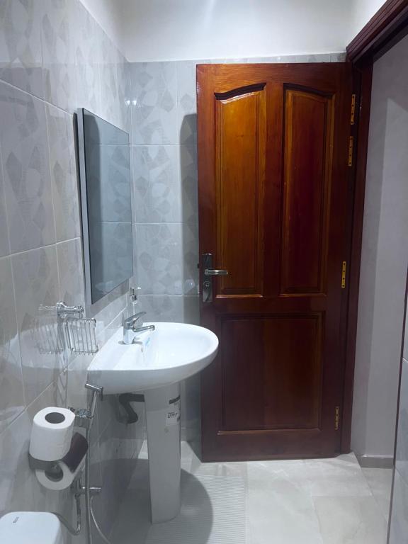 a bathroom with a sink and a toilet and a wooden door at Marrakech Gueliz Rue zellaqa in Marrakech