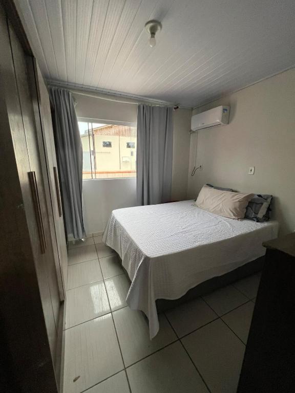 ein Schlafzimmer mit einem Bett und einem Fenster in der Unterkunft Casa completa Beto Carrero in Penha