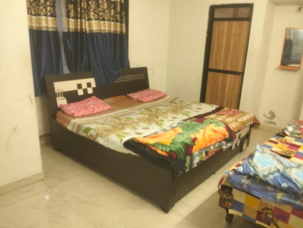 a bedroom with a bed and a window at Gurukrupa Home stay in Rājpīpla