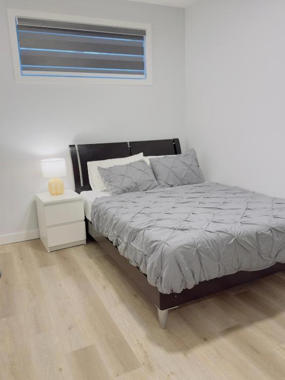 een slaapkamer met een bed en een nachtkastje bij Modern Comfort West Edmonton in Edmonton